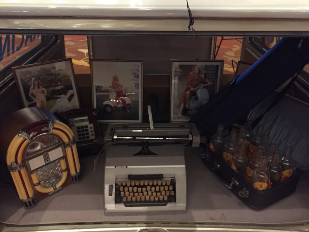 A collection of nostalgic items displayed in the back of a vintage vehicle