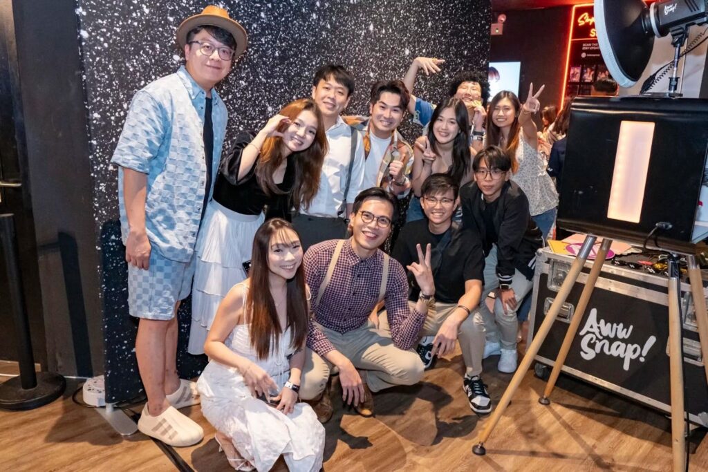 Happy colleagues pose at a corporate event photobooth, illustrating a budget-friendly wow factor.