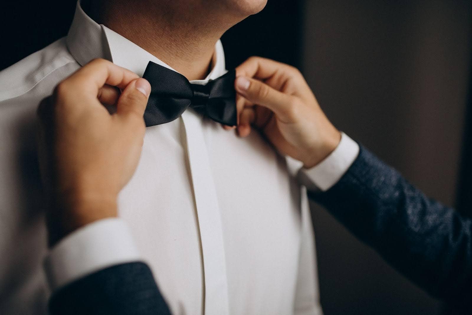 bow tie being tied as a dress code for gala dinner