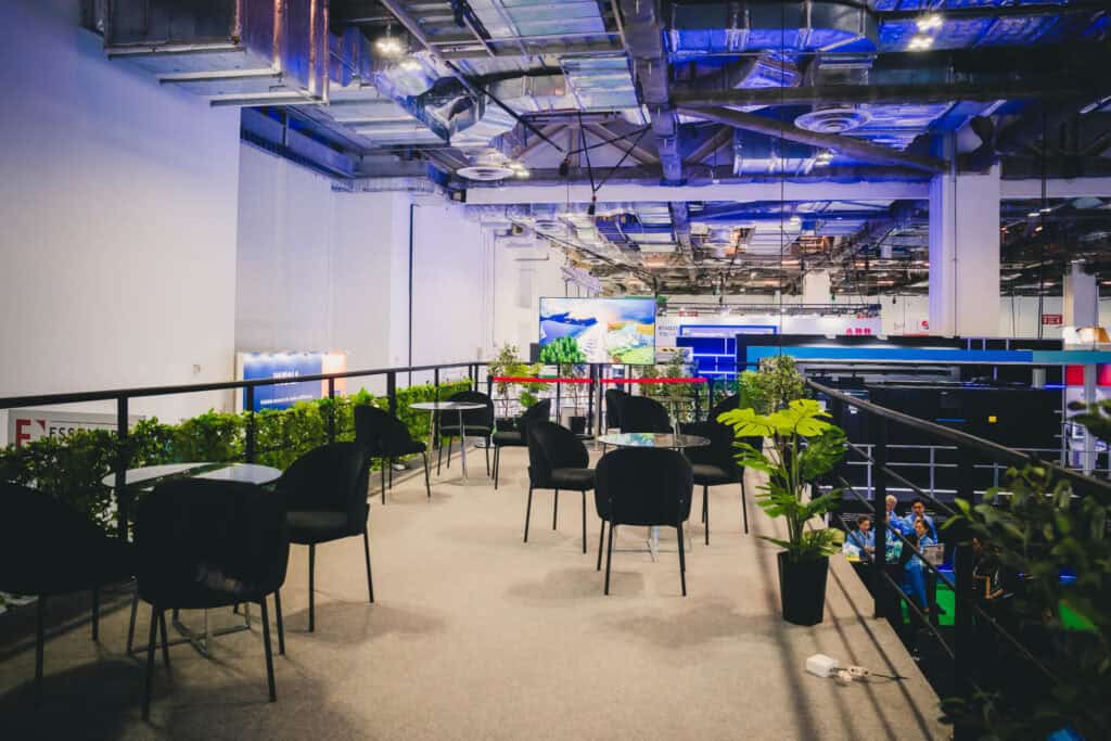 The spacious upper-deck VIP lounge of the Mitsubishi Heavy Industries innovation booth at a trade show.