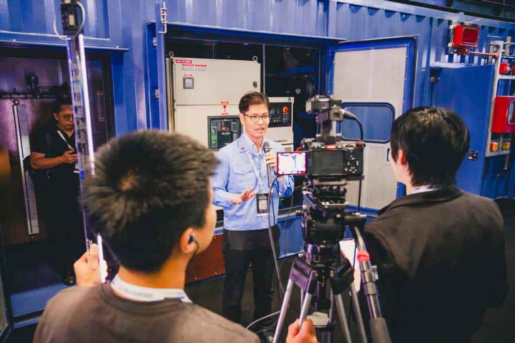 Mitsubishi representative Mr. Yuki Ida explains the features of the MGS2500R containerized generator series during a video interview at Data Centre World Asia.