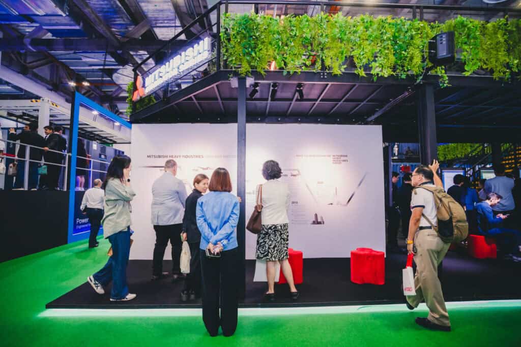 Visitors examine the Mitsubishi Heavy Industries Company History wall at the Data Centre World Asia exhibition