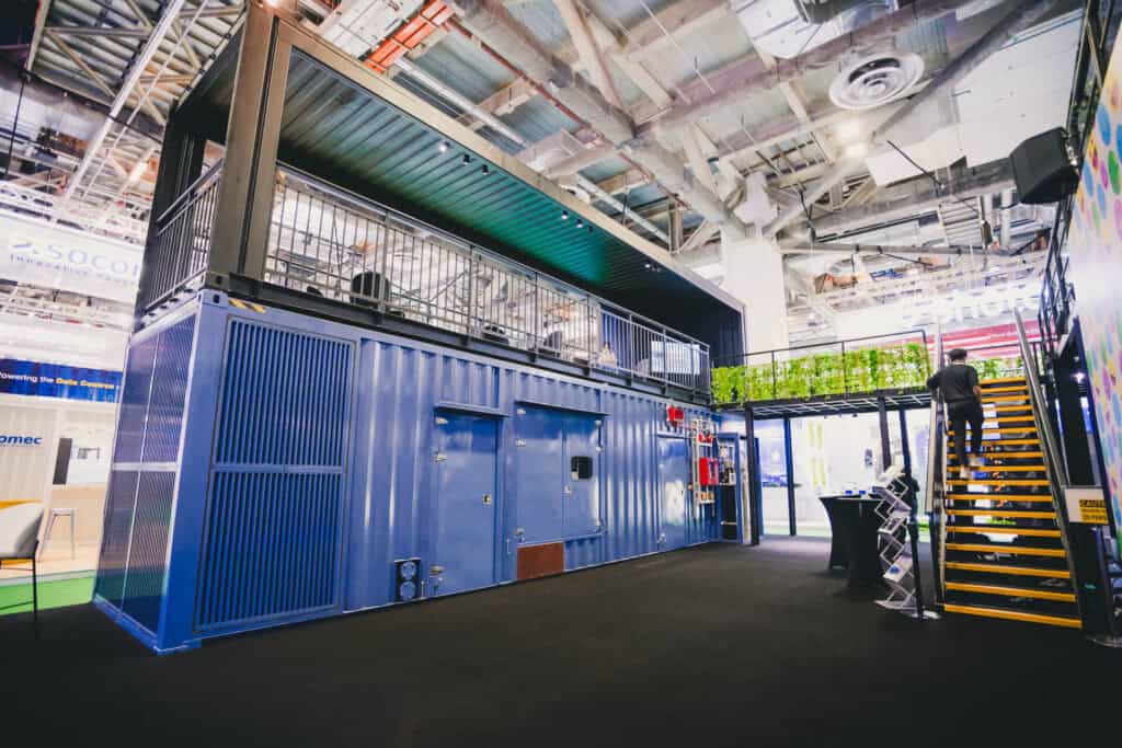 Mitsubishi Heavy Industries' award-winning two-storey innovation booth featuring the MGS2500R containerized generator at a trade show