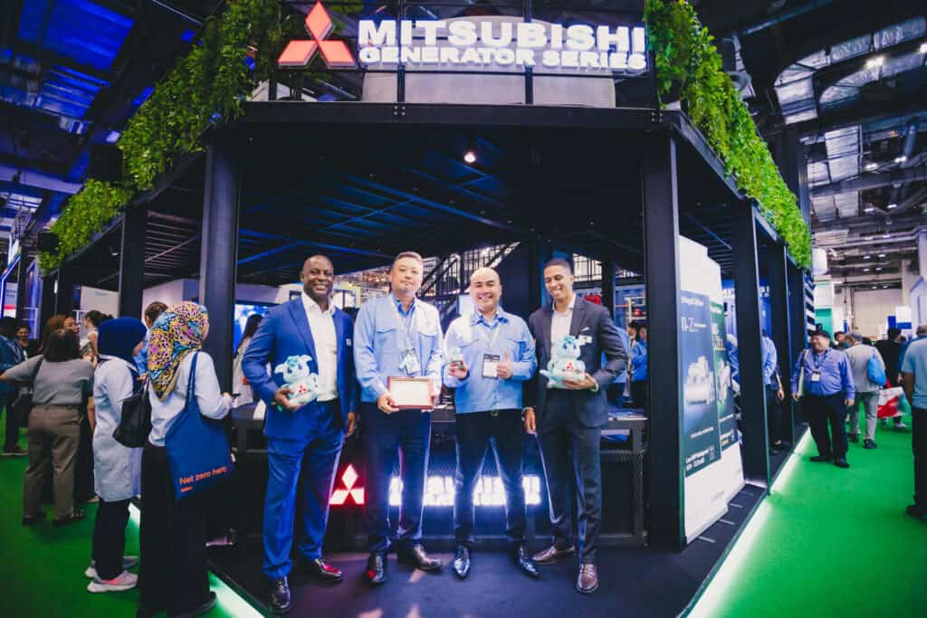 The MHI-ESA team and partners pose with SORA mascot plushies and an appreciation plaque at Data Centre World Asia 2025