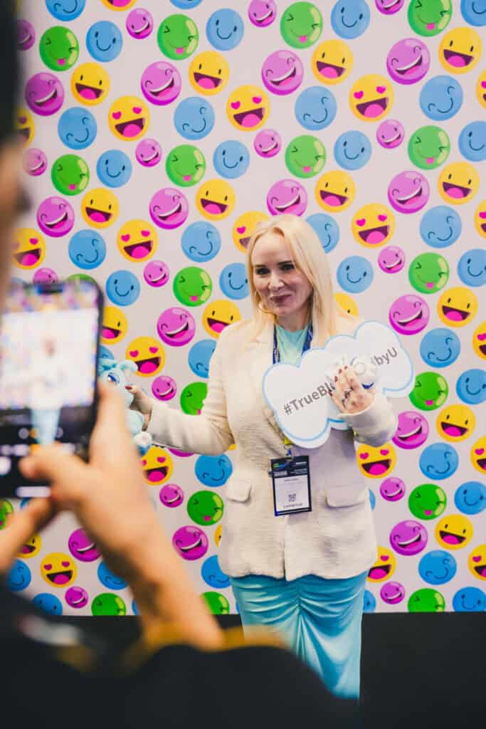 A Mitsubishi exhibitor poses at the #TrueBlueByU photobooth with the Sora dragon mascot at Data Centre World Asia 2025