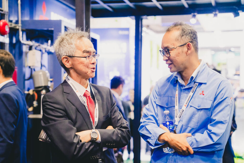 Two professionals engaged in conversation at the trade show booth