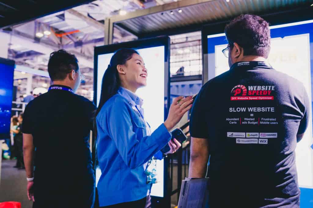 Mitsubishi Heavy Industries staff member engaging with a visitor at a trade show booth.